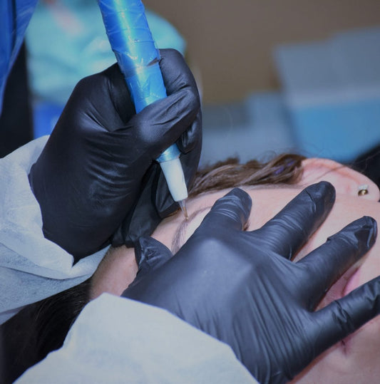 Close-up of a PMU artist performing eyebrow microblading with a handheld machine during training