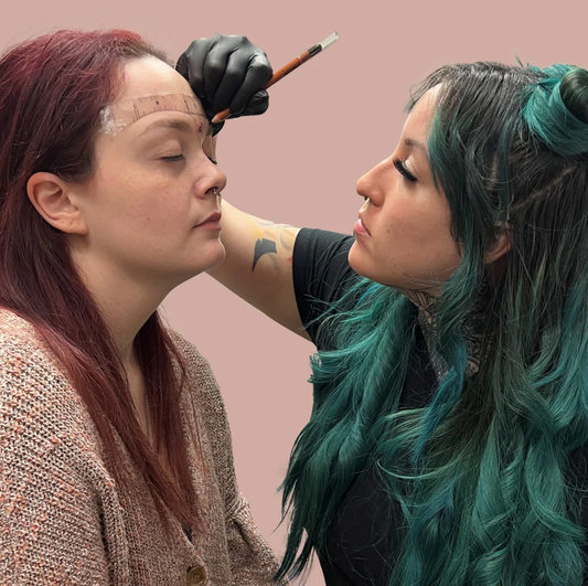 PMU artist performing eyebrow mapping on a client using brow pencil and mapping string