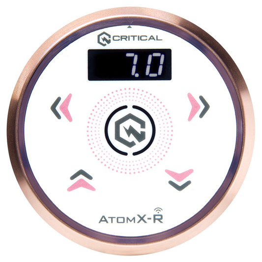 Critical Atom XR rose gold wireless tattoo power supply with digital display, front angle on white background.