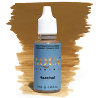 Product photo of Aqua Original Hazelnut pigment bottle with a warm brown brushstroke background. A medium, neutral-brown pigment perfect for brows and eyeliner procedures. Part of the Aqua Original pigment line by Girlz Ink, known for its smooth saturation and natural-healed results