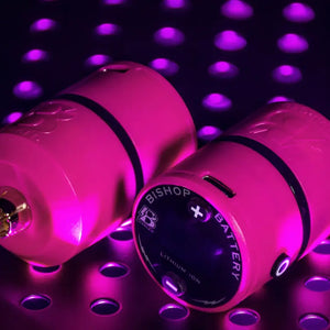 Close-up of Bishop Pink B-Charged V2 Wireless Power Supply featuring RCA connection and lightweight build for tattoo artists.