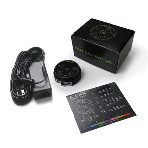 Critical AtomX Power Supply Kit – professional digital PMU and tattoo power unit with magnetic base, power adapter, and voltage guide. Features color-coded voltage display from 1.5V to 17V for precise, consistent performance.
