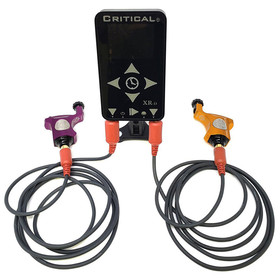 Critical XR-D Power Supply – dual input and dual output digital power unit for PMU and tattoo machines. Shown powering two devices simultaneously with precision voltage control and full-color digital display.
