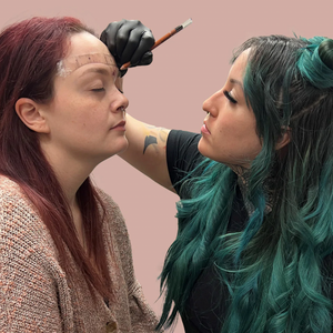 PMU artist performing eyebrow mapping on a client using brow pencil and mapping string