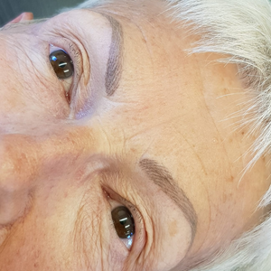 Close-up of healed eyebrows created with Taupe from the Li Pigments Aqua collection by Naomi White. The pigment delivers a soft ash-brown tone ideal for mature clients or those with gray hair, providing natural, balanced permanent makeup results that complement cool undertones.