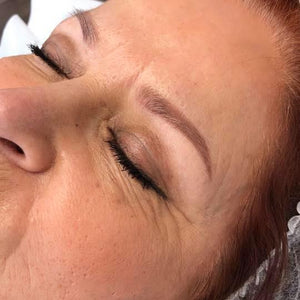 Healed brow result after 6 months using Aqua Auburn pigment by artist Lizabeth Su – soft, natural red-toned brows on fair skin.